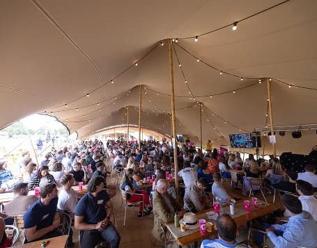 People sitting under a stretch tent